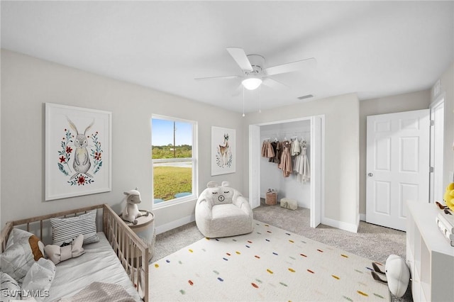 bedroom featuring light carpet, ceiling fan, and a closet