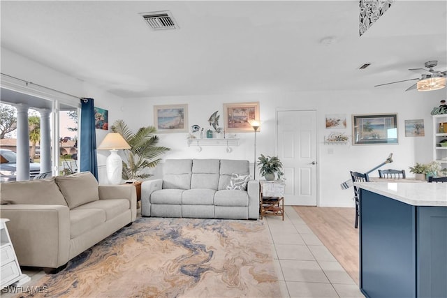 tiled living room with ceiling fan