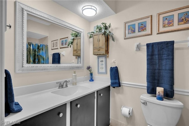 bathroom with toilet, vanity, and a textured ceiling