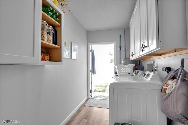 laundry area with washer and dryer, cabinets, a wealth of natural light, and a textured ceiling