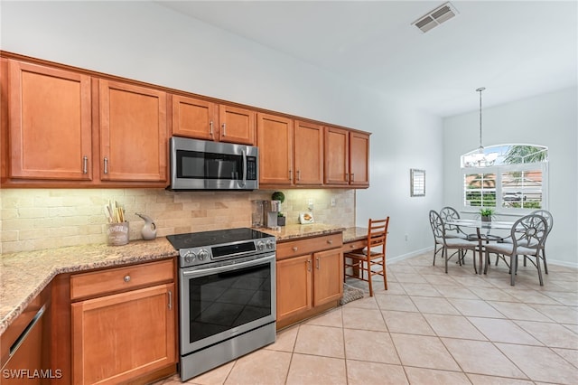 kitchen featuring hanging light fixtures, an inviting chandelier, light stone counters, and stainless steel appliances