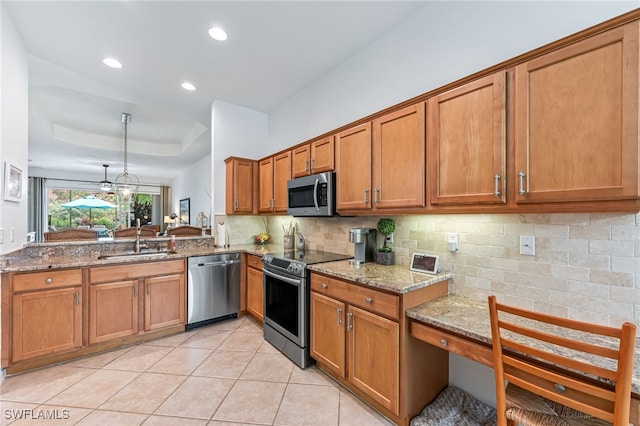 kitchen featuring a raised ceiling, sink, light stone countertops, appliances with stainless steel finishes, and light tile patterned floors