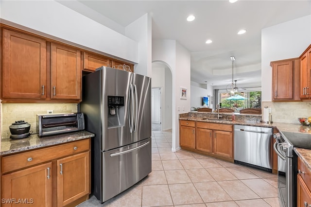 kitchen featuring backsplash, sink, light tile patterned flooring, light stone countertops, and stainless steel appliances