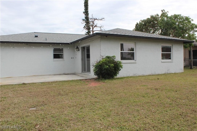 rear view of property featuring a yard and a patio