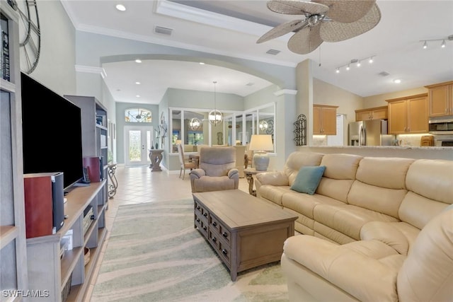 tiled living room featuring vaulted ceiling, ornamental molding, rail lighting, and ceiling fan with notable chandelier