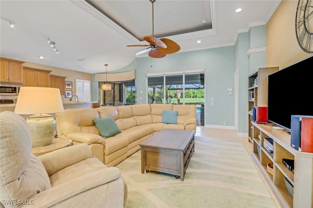 living room featuring a high ceiling, ceiling fan, a tray ceiling, crown molding, and track lighting