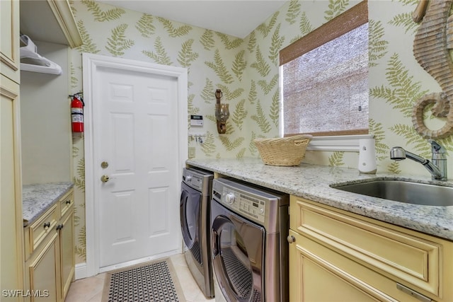 washroom with cabinets, light tile patterned flooring, sink, and washer and clothes dryer