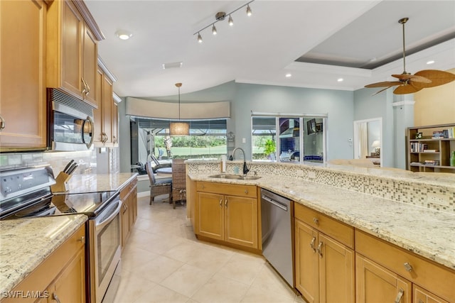 kitchen featuring sink, light stone counters, decorative light fixtures, a raised ceiling, and stainless steel appliances