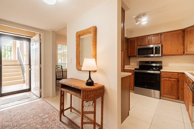 kitchen with light tile patterned floors, plenty of natural light, and appliances with stainless steel finishes