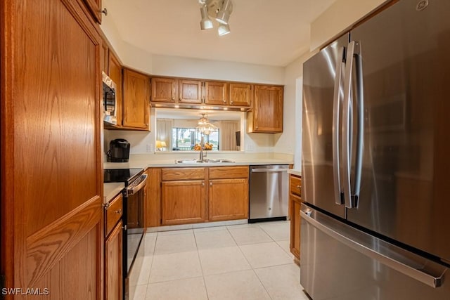 kitchen featuring light tile patterned floors, appliances with stainless steel finishes, and sink