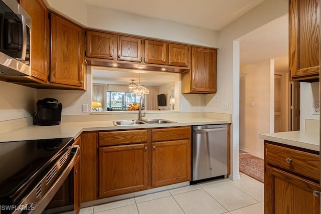 kitchen with decorative light fixtures, a notable chandelier, sink, stainless steel appliances, and light tile patterned floors