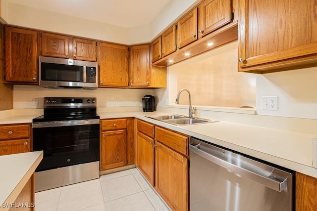 kitchen featuring sink, light tile patterned floors, and stainless steel appliances