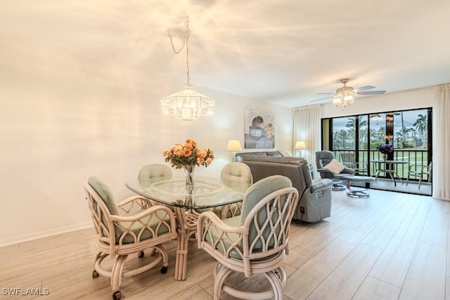 dining area with ceiling fan with notable chandelier and light hardwood / wood-style flooring