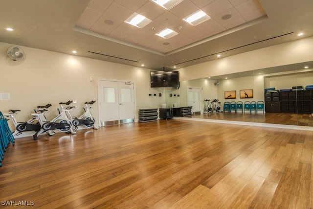 interior space featuring a paneled ceiling, a tray ceiling, and hardwood / wood-style flooring