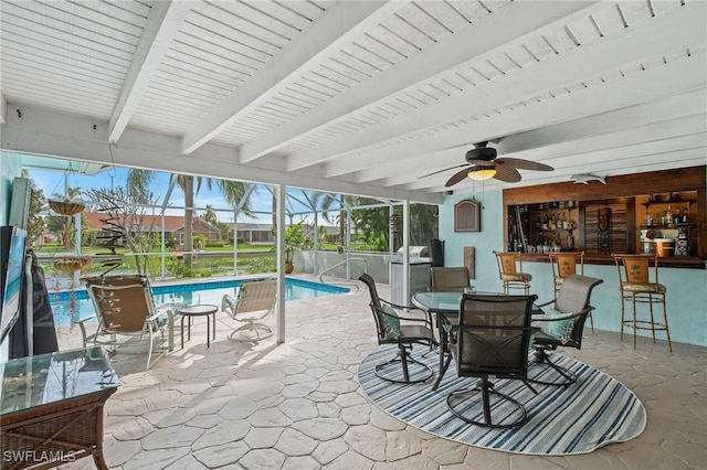 view of patio featuring a lanai, an outdoor bar, and ceiling fan