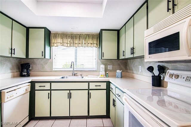 kitchen featuring a tray ceiling, sink, white appliances, and green cabinets