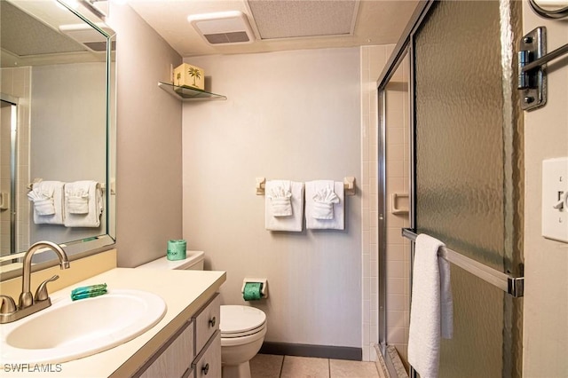 bathroom featuring toilet, tile patterned floors, vanity, and an enclosed shower