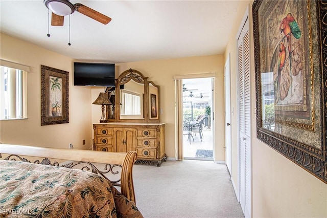 carpeted bedroom with ceiling fan and access to outside