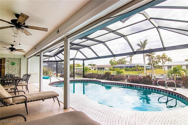 view of pool featuring ceiling fan, glass enclosure, and a patio