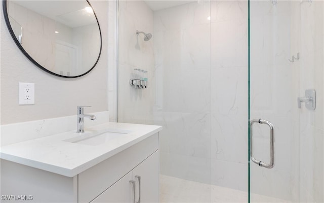 bathroom featuring a shower with shower door and vanity