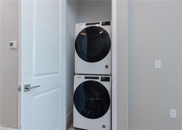 clothes washing area with stacked washer / dryer