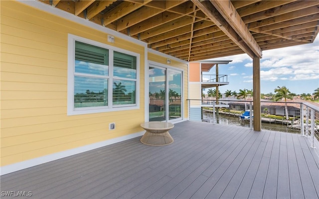 wooden deck with a water view and a boat dock