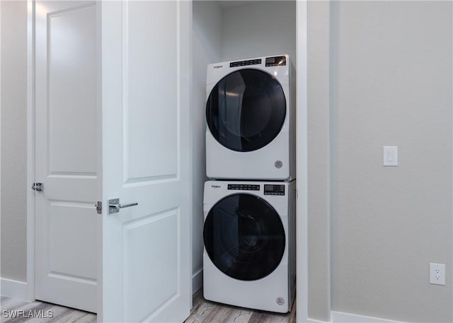 clothes washing area with light wood-type flooring and stacked washer and clothes dryer