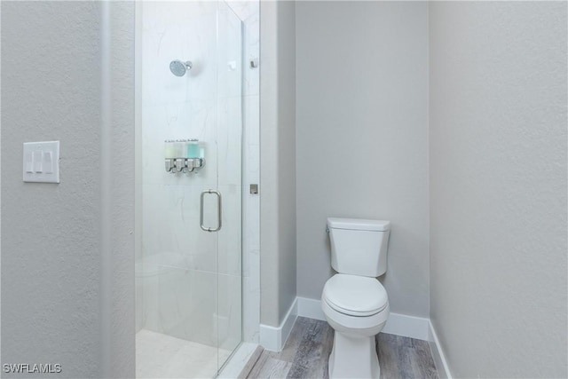 bathroom with hardwood / wood-style flooring, toilet, and an enclosed shower