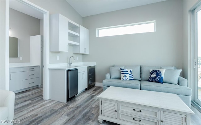 living room featuring wine cooler, light hardwood / wood-style flooring, and sink