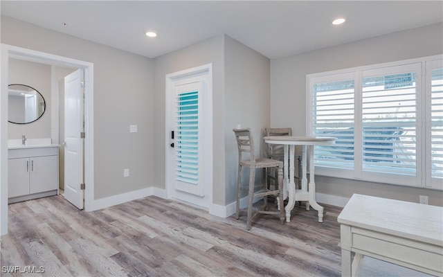 dining area with light wood-type flooring and sink