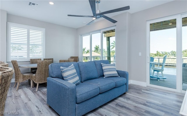 living room featuring ceiling fan and light hardwood / wood-style flooring