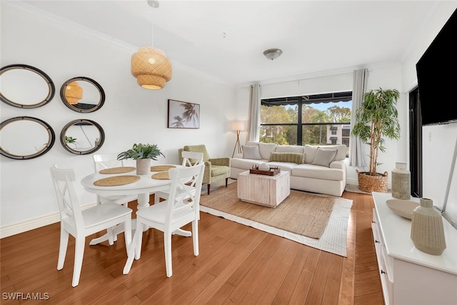 dining space with crown molding and light hardwood / wood-style floors