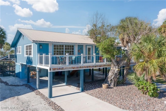 back of house featuring central AC unit, a porch, and a carport