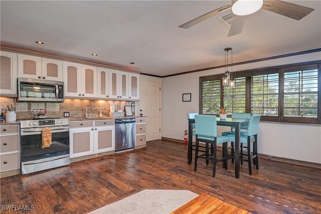 kitchen featuring appliances with stainless steel finishes, decorative backsplash, dark hardwood / wood-style flooring, and white cabinetry