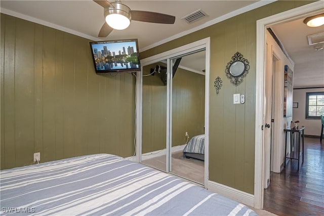 unfurnished bedroom with a closet, ornamental molding, wood-type flooring, and ceiling fan