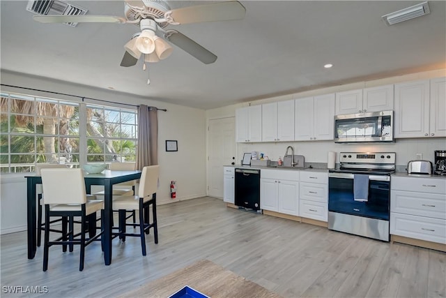 kitchen with white cabinetry, ceiling fan, appliances with stainless steel finishes, light wood-type flooring, and sink