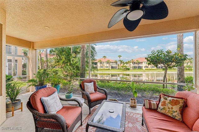 sunroom with a water view, a wealth of natural light, and ceiling fan