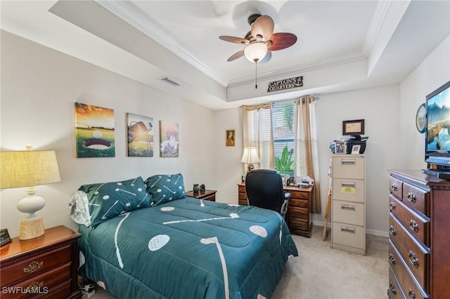 bedroom with light colored carpet, ornamental molding, and a tray ceiling