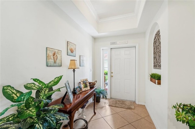 entryway with a tray ceiling, light tile patterned floors, and crown molding