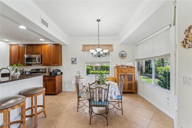 tiled dining room featuring crown molding, sink, and an inviting chandelier