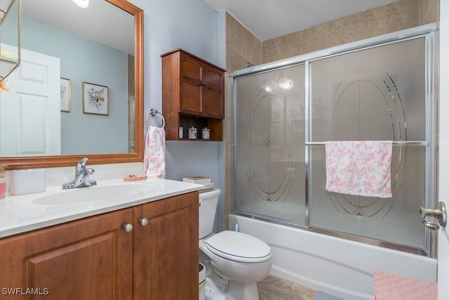 full bathroom featuring toilet, vanity, tile patterned floors, and combined bath / shower with glass door