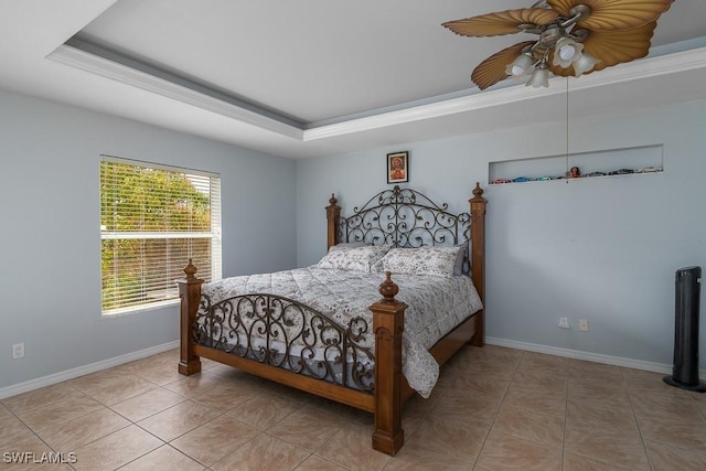 tiled bedroom with ceiling fan and a tray ceiling