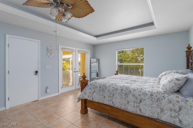 bedroom featuring ceiling fan, a tray ceiling, access to outside, and light tile patterned flooring