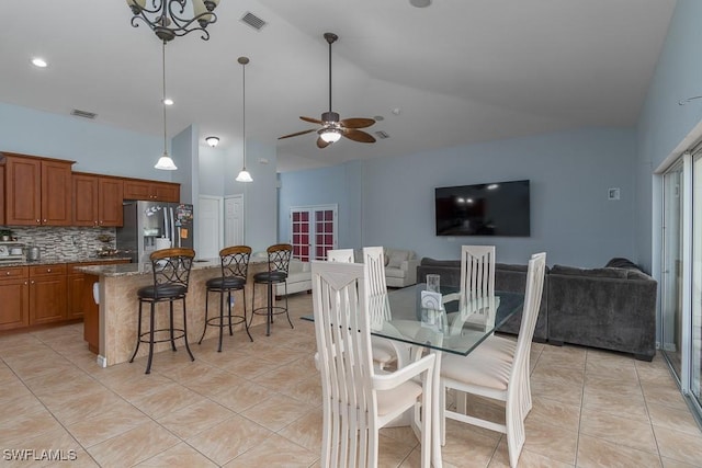 dining room featuring light tile patterned flooring, lofted ceiling, and ceiling fan with notable chandelier