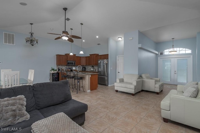 living room with ceiling fan, light tile patterned flooring, french doors, high vaulted ceiling, and sink