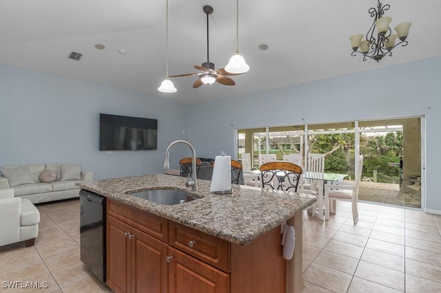 kitchen featuring light stone countertops, decorative light fixtures, black dishwasher, sink, and a center island with sink