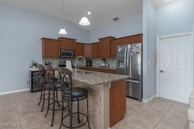 kitchen featuring appliances with stainless steel finishes, backsplash, dark stone countertops, high vaulted ceiling, and sink