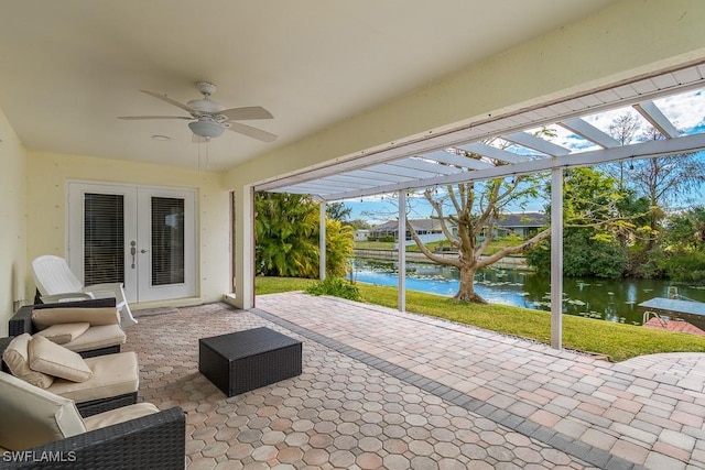 view of patio with ceiling fan, french doors, a water view, and a pergola