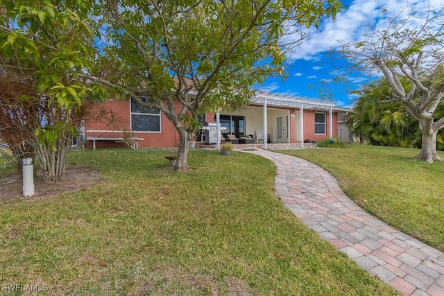 back of house featuring a lawn and a pergola