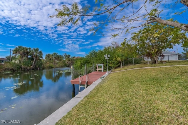 dock area featuring a water view and a lawn